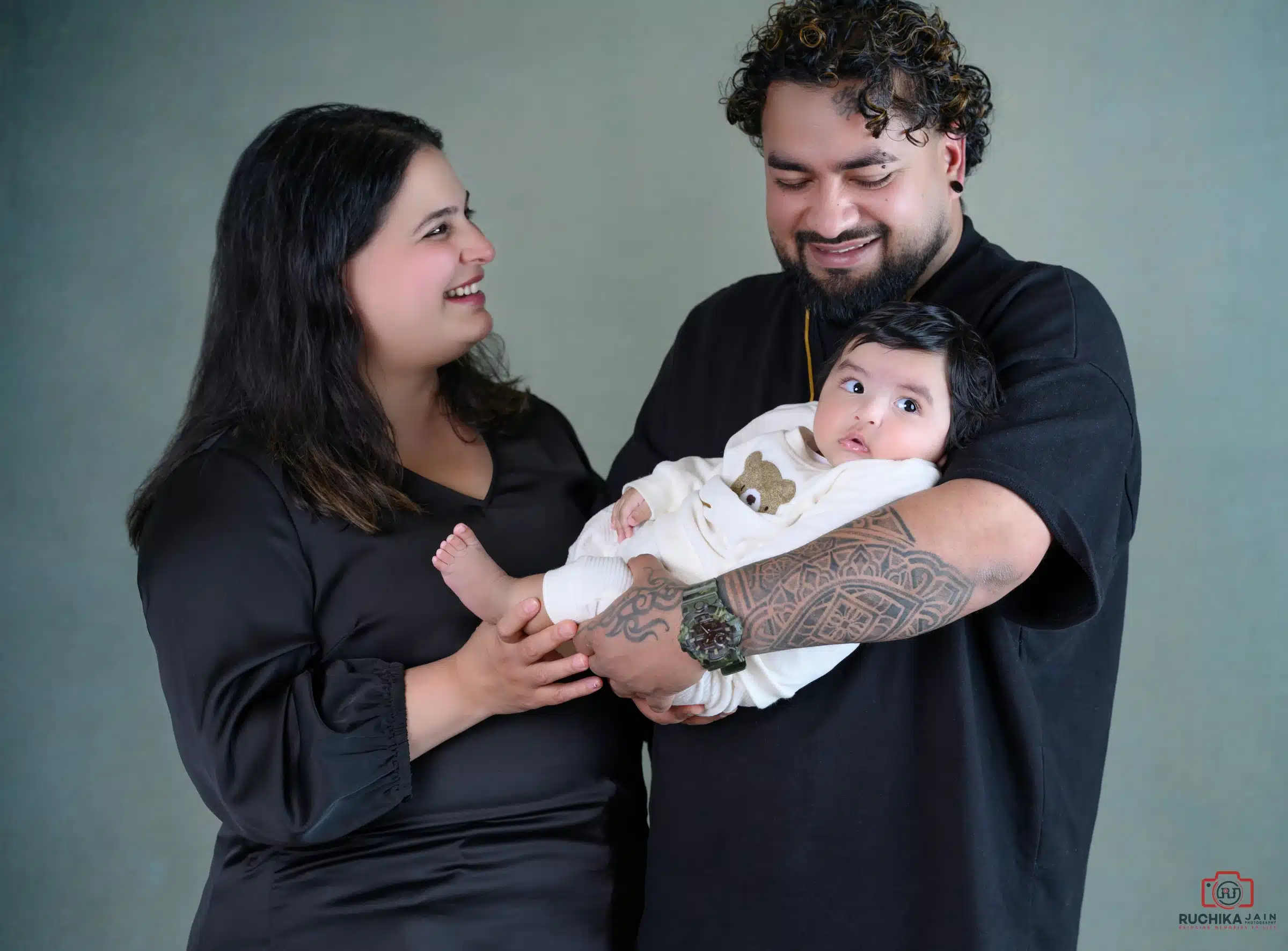 Happy parents holding their baby during a relaxed and modern family photoshoot in Wellington